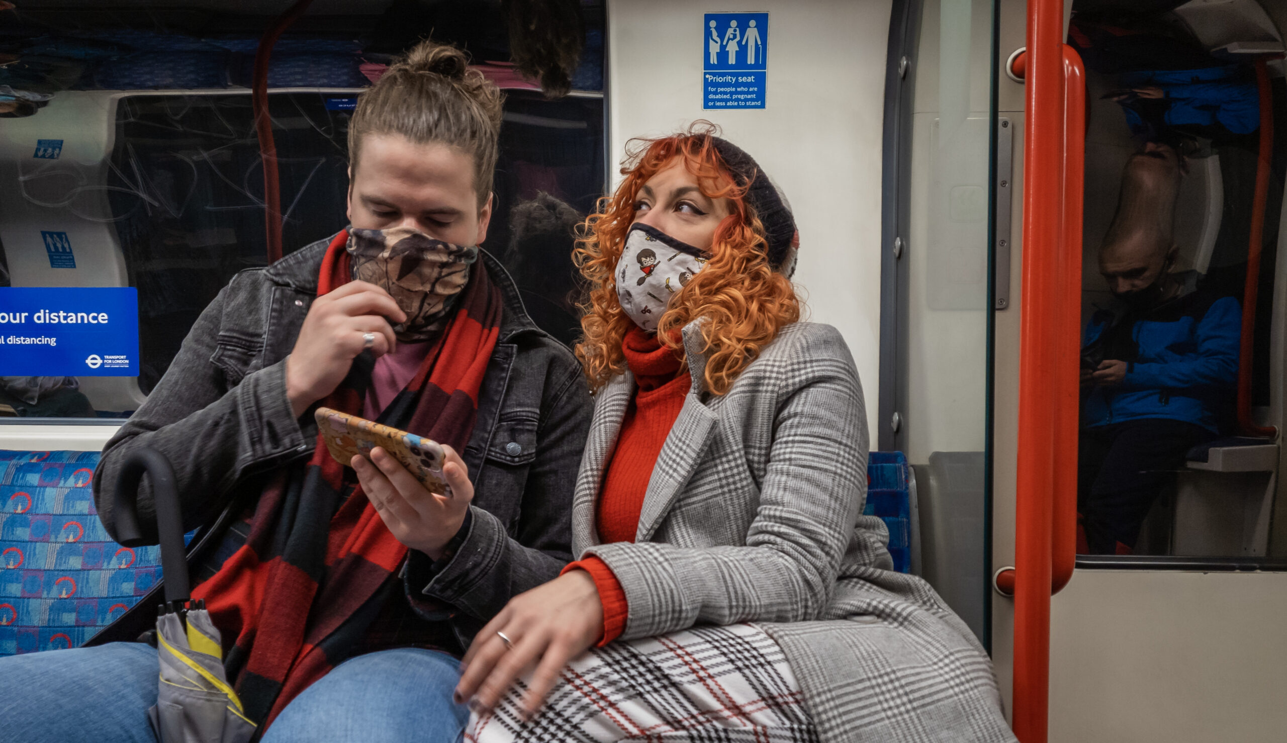 man and woman wearing face coverings on Tube