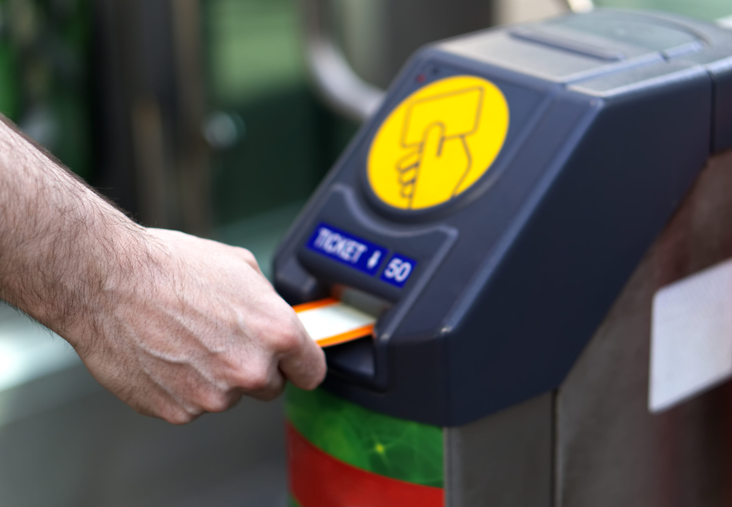 Man putting train ticket at gate barrier