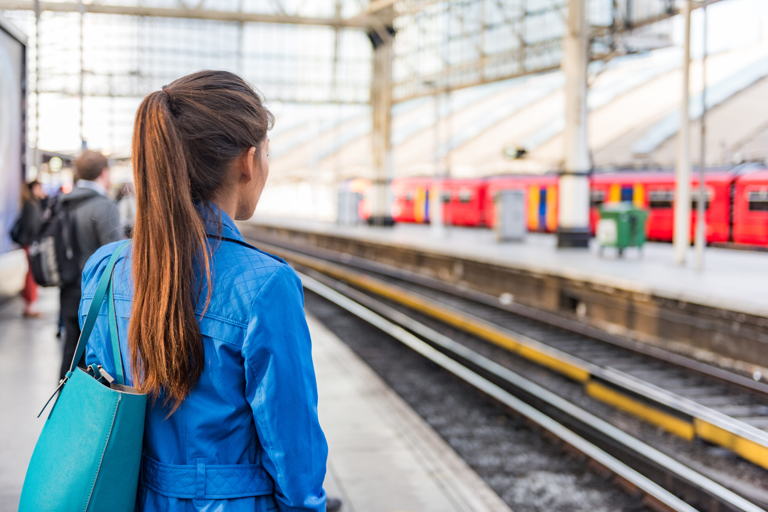Woman waiting at station platform for train