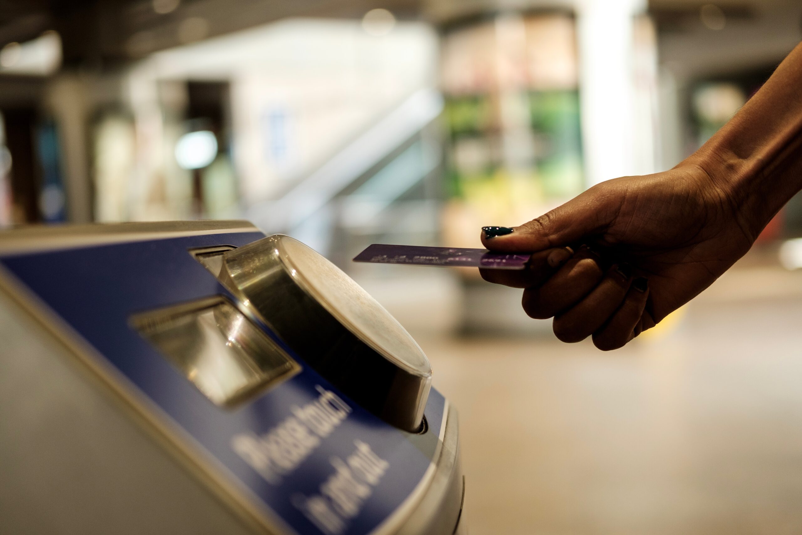 Woman using TfL contactless reader with her bank card