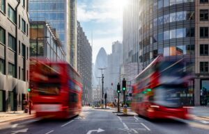 Buses in motion with city in the background