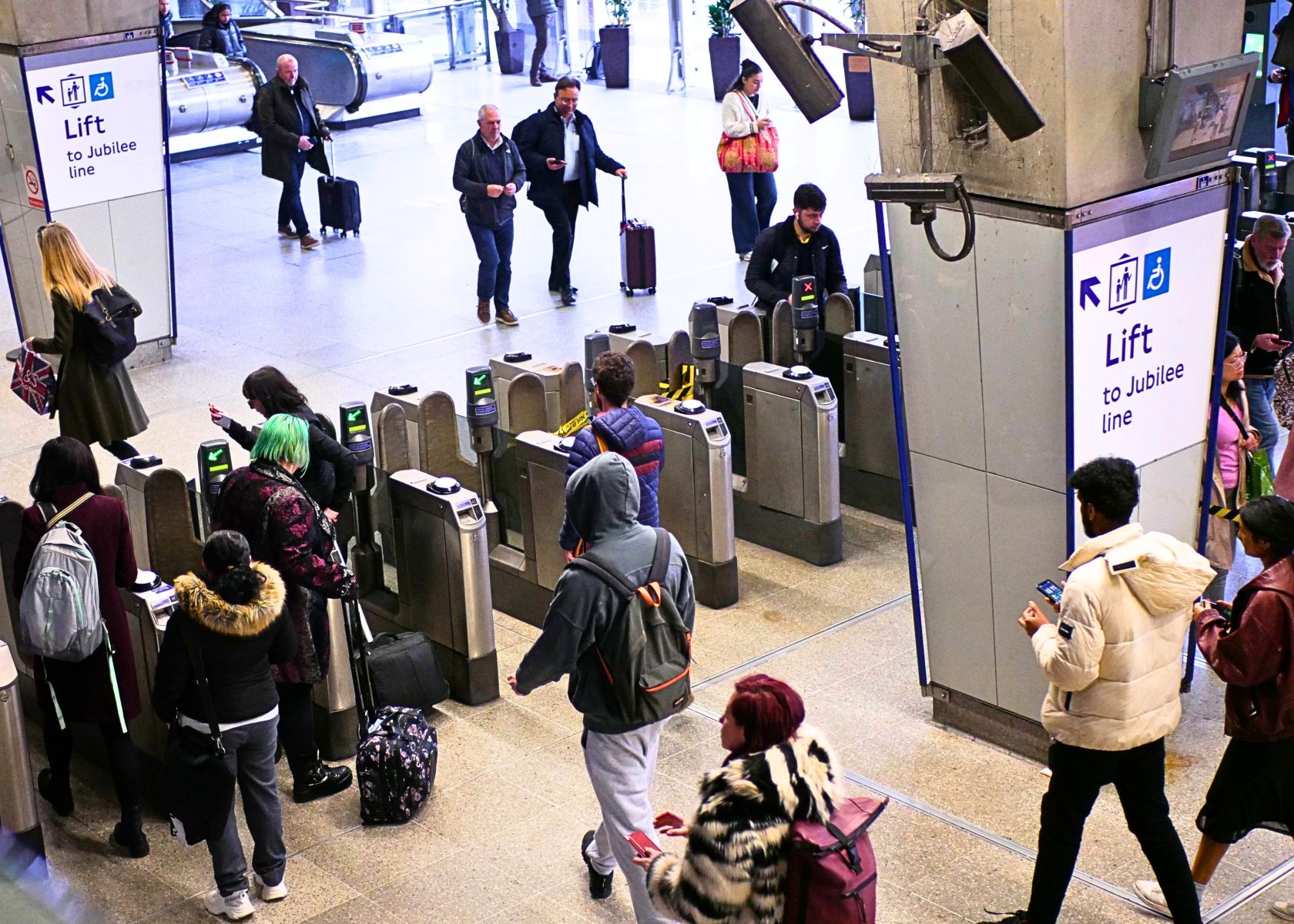 A busy station with people walking through ticket barriers