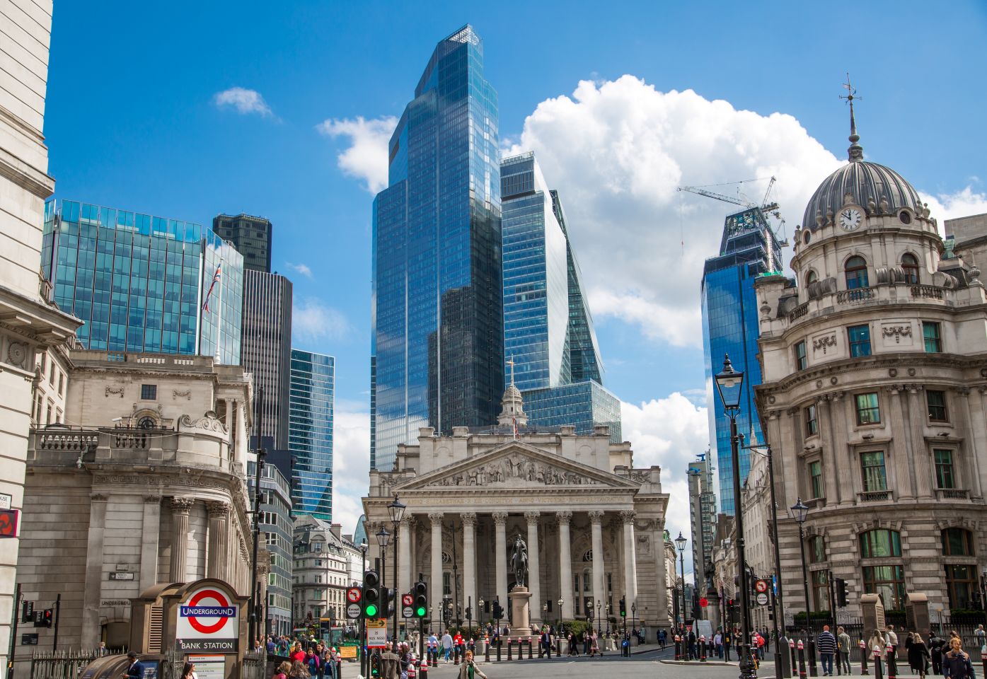 London's bank building with city skyscrapers in the background, against a blue sky with clouds