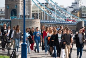 Pedestrians walking on the street with Tower Bridge in the background