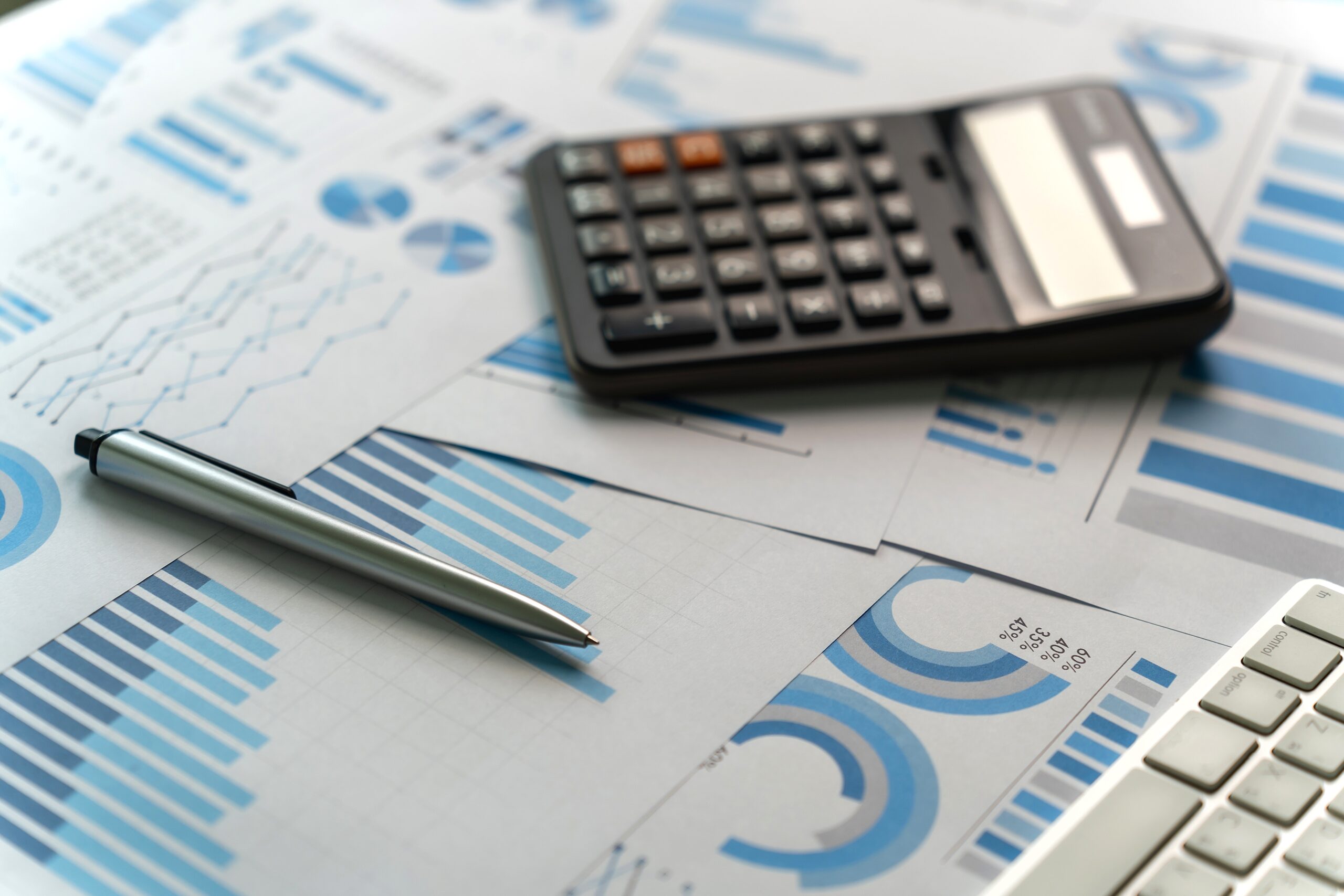 A calculator on top of documents featuring various graphs