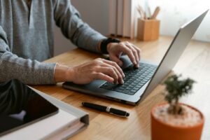 Hands typing on a laptop keyboard